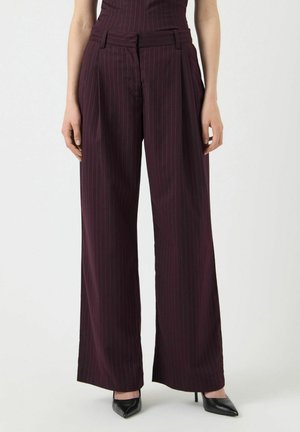 Pantaloni a vita alta di colore bordeaux con gambe larghe a righe verticali, dotati di passanti per cintura e pieghe anteriori. Tessuto morbido con un aspetto sartoriale.