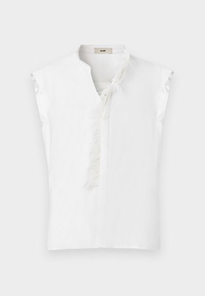 Λευκό αμάνικο μπλουζάκι με λεπτομέρειες φτερών κατά μήκος του μπροστινού λαιμού και ελαφρώς σε σχήμα V για το γιακά, εμφανιζόμενο σε απλό φόντο.