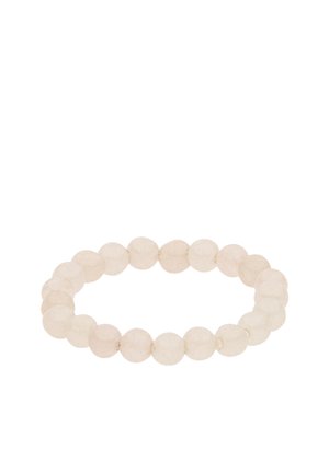 Stretch bracelet made of round translucent white beads arranged in a circle on a white background.