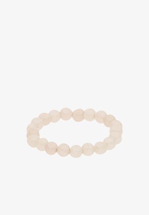 Stretch bracelet made of round translucent white beads arranged in a circle on a white background.
