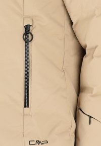Beige quilted jakke med en glat tekstur, med en sort lynlås foran og et CMP-logo nær kanten.