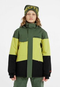 Veste colorée en vert et jaune avec fermeture éclair, poches et capuche. Texture douce et accents noirs. Logo "PROTEST" sur la poitrine.