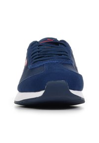 Baskets en suede marine avec des accents en maille, présentant une semelle intermédiaire blanche et une marque rouge sur la languette. Bout arrondi et semelle extérieure en caoutchouc plat.