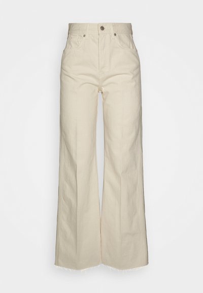 Beige vide benbukser laget av bomull, med høy midje, frontlommer og frynsete hem for en strukturert finish.