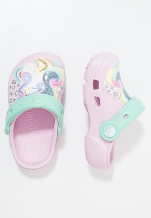 Børns lyserøde Crocs-træsko med pastelgrønne stropper og glitrende enhjørninge- og regnbuedesign på tæerne.