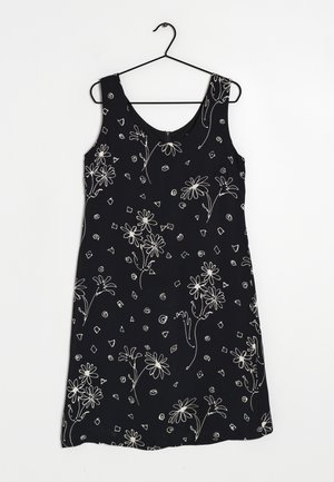 Robe noire sans manches avec des motifs floraux et géométriques blancs. Tissu doux avec une texture lisse et décolleté arrondi.
