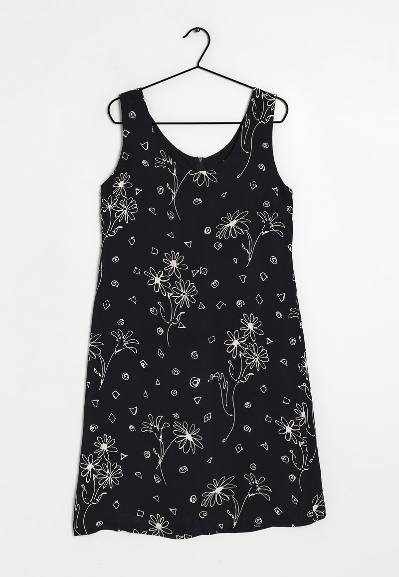 Svart ärmlös klänning med vita blommönster och geometriska mönster. Mjuk tyg med en slät textur och rundad halsringning.