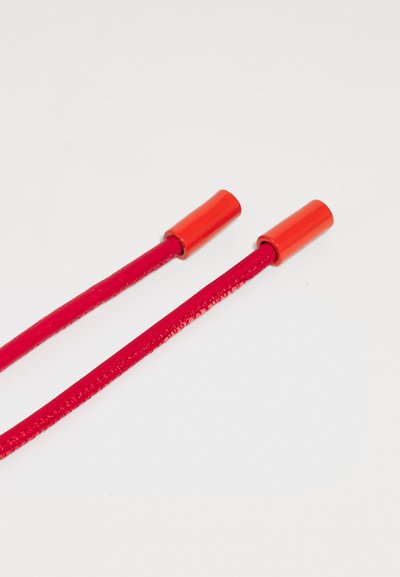 Cuerdas de zapato rojas con aglets rojos brillantes, hechas de un material texturizado, que exhiben una superficie suave y brillante, así como un color uniforme en toda su extensión.