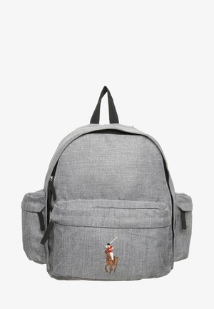 Grauer Stoffrucksack mit vorderen und seitlichen Reißverschlusstaschen, schwarzen Griffen und einem kleinen, gestickten Polospieler in Rot und Weiß auf der Vorderseite.
