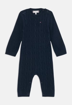 Tengerészkék, kötött bodysuit hosszú ujjakkal, vállon gombokkal és az alján snap záródással a könnyű öltözködés érdekében.