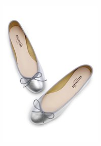 Ballerine argentate con punta rotonda metallica e un fiocco decorativo, presentano un esterno liscio, suola imbottita e bordatura sottile.