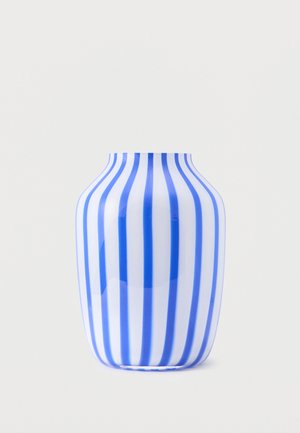 Fehér kerámia váza egyenletesen elhelyezett, függőleges kék csíkokkal, lekerekített testtel és keskeny nyitott felső résszel, letisztult világos háttér előtt.