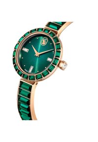 Zielony metaliczny zegarek z różowozłotą kopertą, zielonymi kamieniami w kształcie szmaragdu na bransolecie oraz zieloną tarczą w wzór promieni słonecznych z prostokątnymi znacznikami.