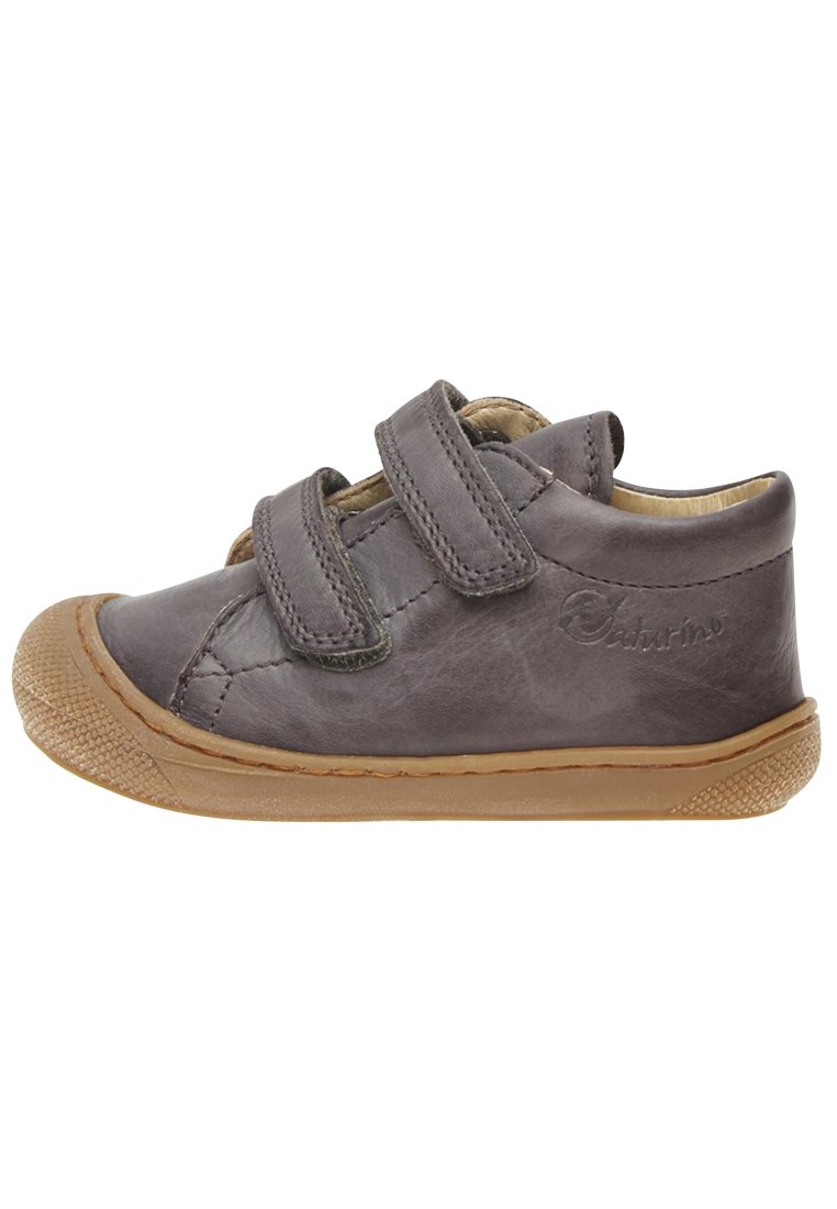 Zapatos para toddlers de cuero gris con dos correas de Velcro, punta redondeada y suela de goma beige con detalles texturizados en la puntera.