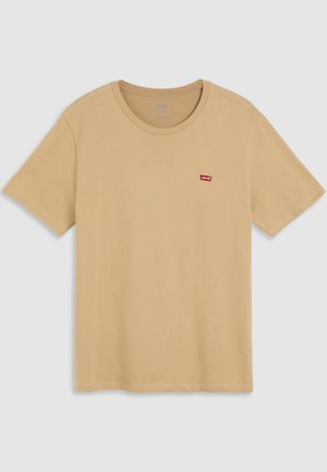 Bež pamučna majica s kratkim rukavima i okruglim izrezom, s malim crvenim Levi's logom na lijevoj strani prsnog koša. Glatka tekstura.