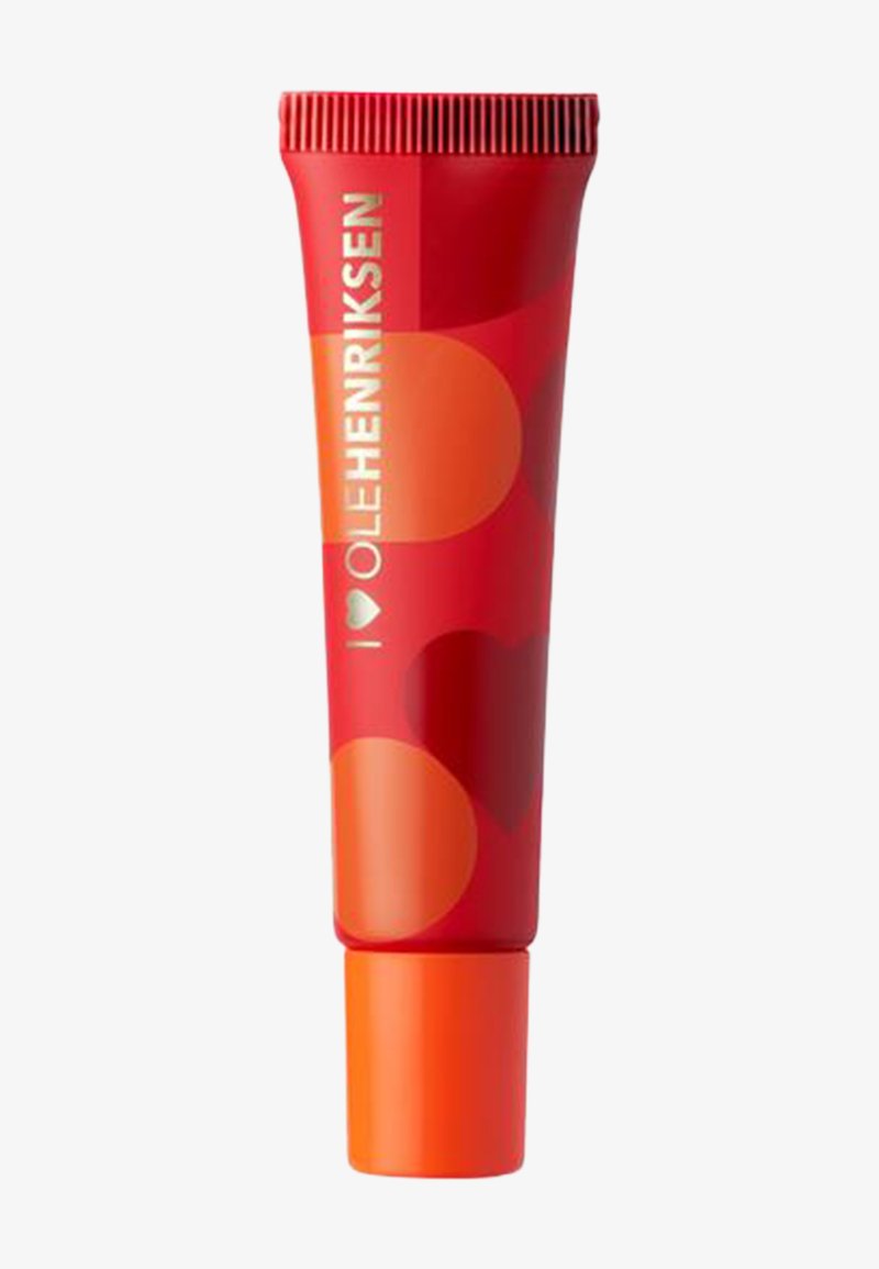 Tube compressible rouge avec un bouchon orange, présentant des motifs circulaires dans des nuances variées de rouge et d'orange. Le nom de la marque est imprimé en blanc.