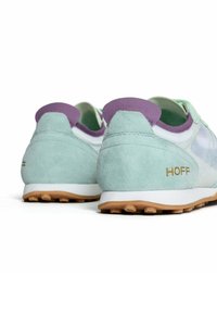 Zapatillas de ante verde menta con acentos morados y una media suela blanca. "HOFF" está estampado en dorado en el talón. Suela de goma texturizada.