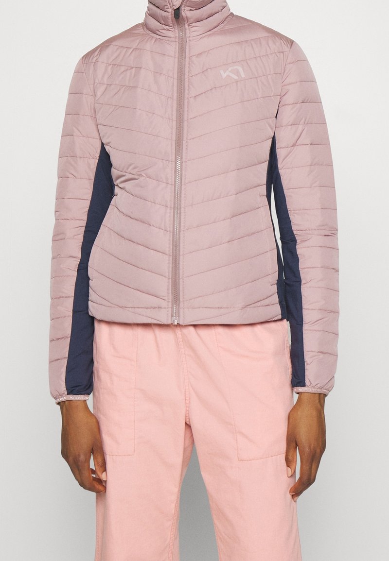 Różowa pikowana kurtka z wysokim kołnierzem, z granatowymi panelami bocznymi i przednim zamkiem błyskawicznym. Tkanina o fakturze, lekka konstrukcja.