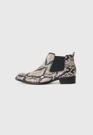 Knöchelhoher Chelsea-Stiefel mit schwarzem und beigem Schlangenledermuster, elastischen Seitenpaneelen und niedrigem schwarzen Absatz auf einem schlichten Hintergrund.