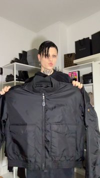 Μαύρο χοντρό μπουφάν με ψηλό γιακά, μπροστινό φερμουάρ και δύο πλαϊνές τσέπες. Διαθέτει λείο υφή και ελαστικές μανσέτες. Χωρίς ορατά λογότυπα.