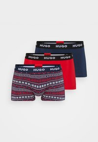 Drei Paare Herrenunterhosen: eine einfarbig rote, eine einfarbig marineblaue und eine mit Schneeflocken und "HUGO" in Marineblau und Rot. Jede hat einen schwarzen Bund.