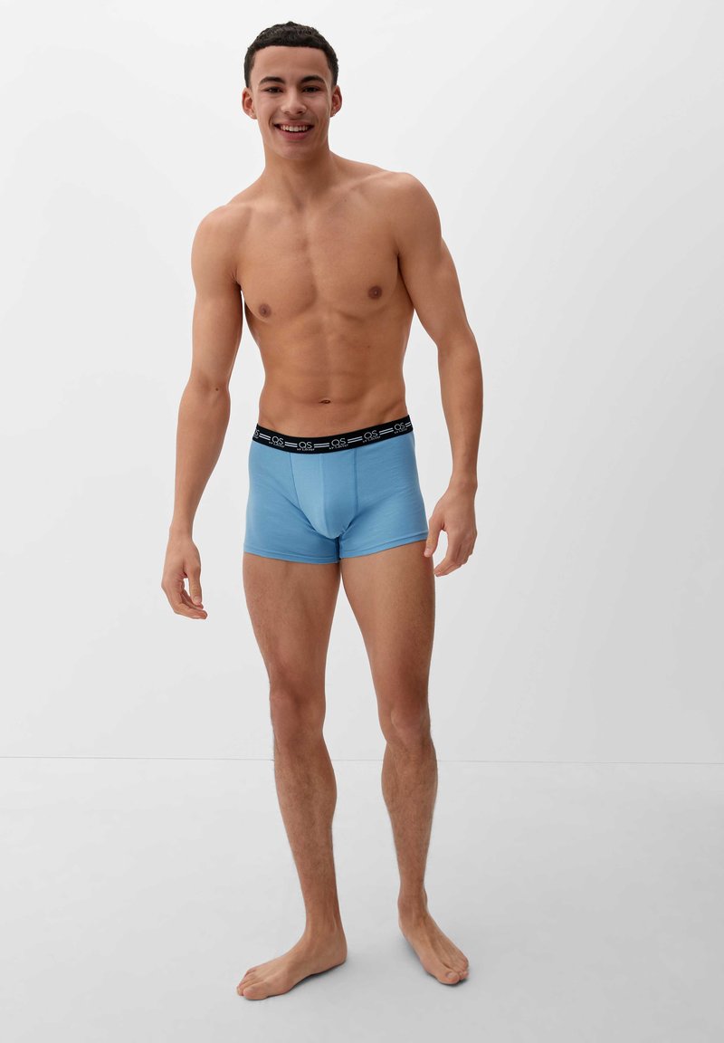 Lichtblauwe boxershorts met een zwarte elastische tailleband met het merkembleem. Glad textuur met een nauwsluitend ontwerp.