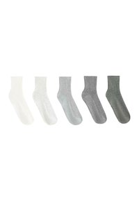 Cinq paires de chaussettes côtelées mi-mollet alignées côte à côte, dégradé de couleur du blanc au gris foncé.