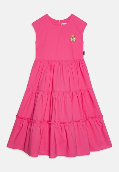 Rosa bomullskjole med en tilpasset bodice, lagdelte volanger og et bjørnepatch på brystet. Glidelås bak og korte ermer.