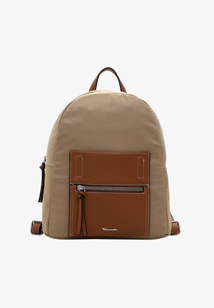 Beige canvas backpack with a brown leather front pocket. Features silver zipper and stitching details. Adjustable straps and top handle.