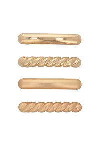 Tre fermagli metallici per capelli in tonalità dorate: uno liscio, uno con design attorcigliato e uno rotondo con una finitura lucida.