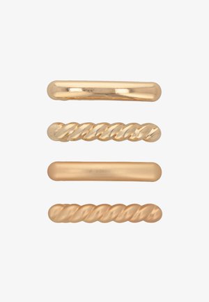 Tre fermagli metallici per capelli in tonalità dorate: uno liscio, uno con design attorcigliato e uno rotondo con una finitura lucida.