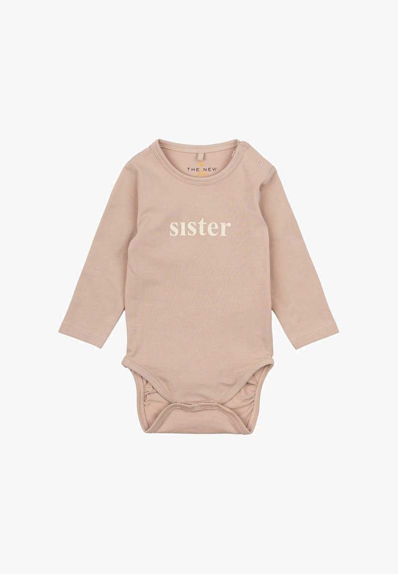 Ilgų rankovių bodžis šviesiai rožinės spalvos medvilnės, su apvaliu kaklo iškirpimu ir užsegimu petyje. Priekinėje dalyje balta spalva užrašyta "Sesuo". Minkšta tekstūra.