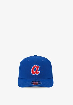 Blue baseball cap with a red lowercase "a" outlined in white and light blue on the front panel, flat brim, and adjustable snapback.