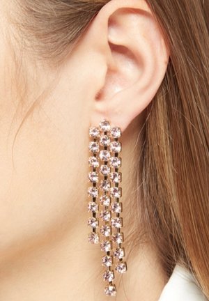 Boucles d'oreilles pendantes dorées avec plusieurs gemmes roses disposées en un motif en cascade. Les boucles d'oreilles pendent sous le lobe de l'oreille, mettant en valeur leur longueur.