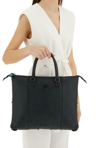 Borsa tote in pelle nera con superficie testurizzata, doppi manici superiori e logo. Presenta una chiusura a zip e accessori metallici.