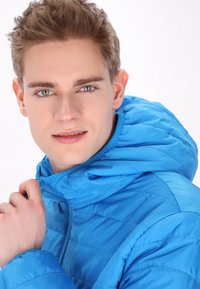 Giacca blu imbottita con cappuccio, dotata di chiusura zip e texture liscia. Il design include dettagli cuciti e una finitura in tessuto resistente.