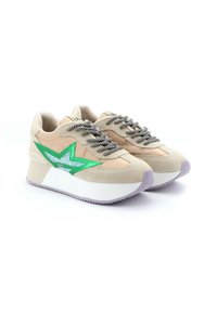 Beige suède sneakers met groene en zilveren steraccenten, dikke witte zolen en zwart-witte gestreepte veters.