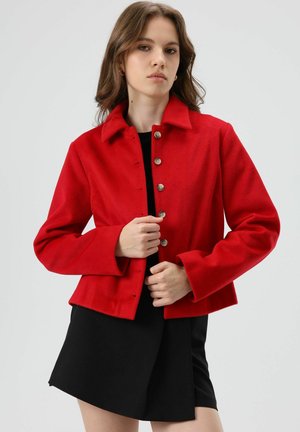 Rode wollen jas met een kraag, knoopsluiting met vijf knopen aan de voorkant en lange mouwen. Glad oppervlak met een cropped pasvorm.