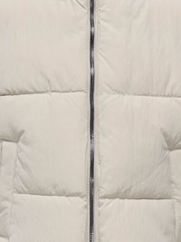 Ανοιχτό μπεζ φουσκωτό μπουφάν με κατακόρυφο φερμουάρ και διακριτική γυαλάδα. Διαθέτει ραμμένα τμήματα και πλαϊνές τσέπες. Απαλή, επενδεδυμένη υφή.