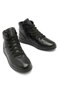 Czarne skórzane buty typu high-top z teksturowanym wykończeniem, z okrągłym czubkiem, płaskimi sznurówkami i wzmocnioną konstrukcją kostki.
