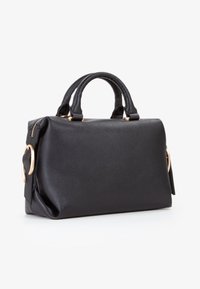 Sort tekstureret lædertaske med to korte håndtag, hardware i guldtoner og sidelukninger, placeret på en hvid baggrund.