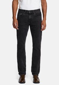 Les jeans en denim noir présentent une coupe droite, un design à cinq poches et un léger délavage. Les accents incluent une taille avec passants de ceinture et des détails de couture discrets.