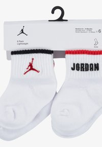 Valged sääresokid kuuekomplektis, punase ja musta sooniku äärega, punase Jumpmani logoga ja musta "JORDAN" tekstiga. Sobivad vastsündinutele vanuses 6–12 kuud.