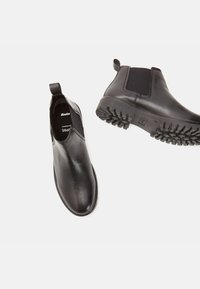 Czarne skórzane buty chelsea z elastycznymi panelami bocznymi i teksturowaną gumową podeszwą, z pętelką na pięcie dla łatwego zakładania.