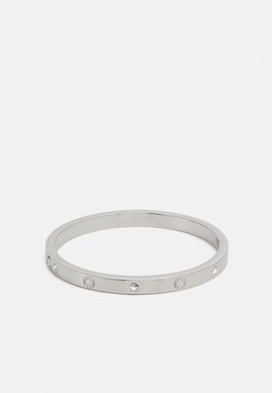 Sølv armbånd med en glatt metallisk overflate, med inngravert symboler og små klare krystaller jevnt fordelt rundt båndet.