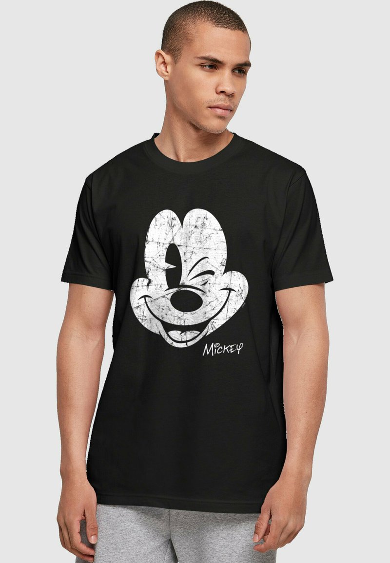 Camiseta de algodón negra con un gráfico desgastado en blanco de la cara de Mickey Mouse y su firma, cuello redondo y mangas cortas.