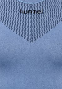 Jasnoniebieska koszulka sportowa z teksturowanym wzorem w poziome paski, okrągłym dekoltem i czarnym logo "hummel" na klatce piersiowej.