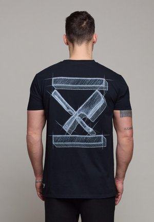 Mann sett bakfra iført svart T-skjorte med hvit skisse av kryssede kjøttkniver på ryggen mot en ensfarget bakgrunn.