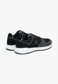 Czarne i szare buty sportowe wykonane z zamszu i siateczki, z wyściełanym kołnierzem oraz białą gumową podeszwą z teksturowanym bieżnikiem.