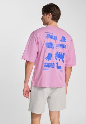 Lys pink oversized t-shirt med blå grafik af forskellige stole på bagsiden, korte ærmer og rund halsudskæring.